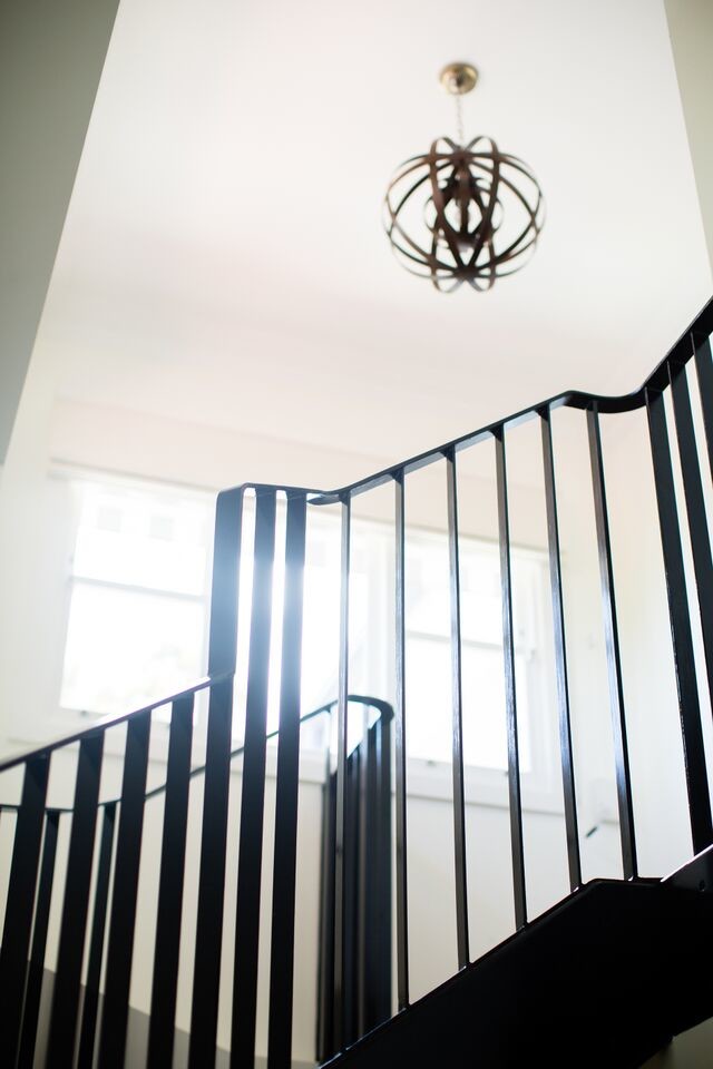 Foto de escalera curva minimalista grande con escalones de madera, contrahuellas de madera pintada y barandilla de metal