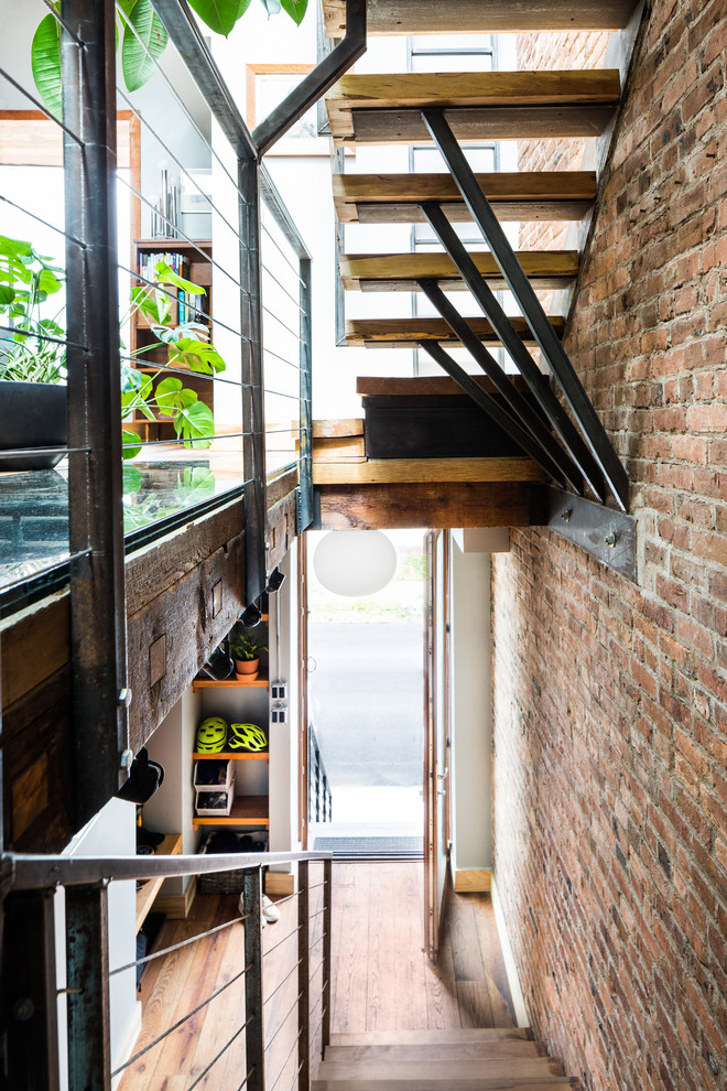 Urban wooden floating open and metal railing staircase photo in New York