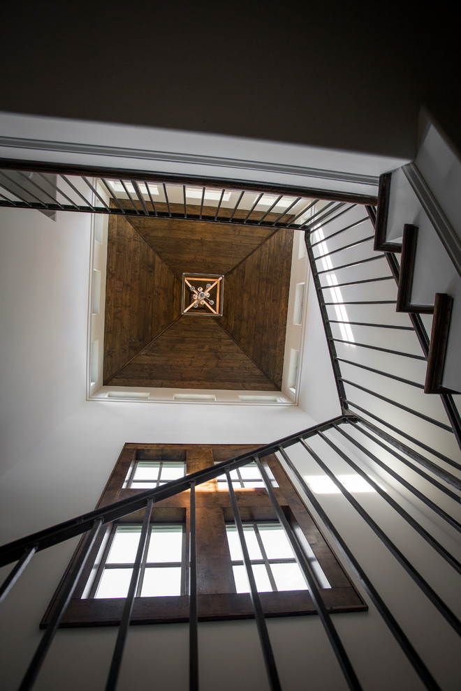 Imagen de escalera en U tradicional renovada grande con escalones de madera, contrahuellas de madera pintada y barandilla de metal