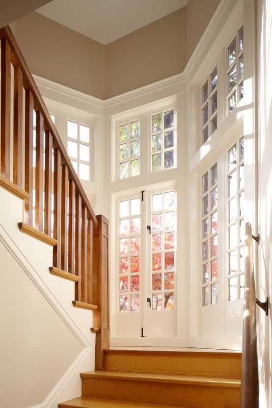 На фото: большая п-образная деревянная лестница в классическом стиле с деревянными ступенями