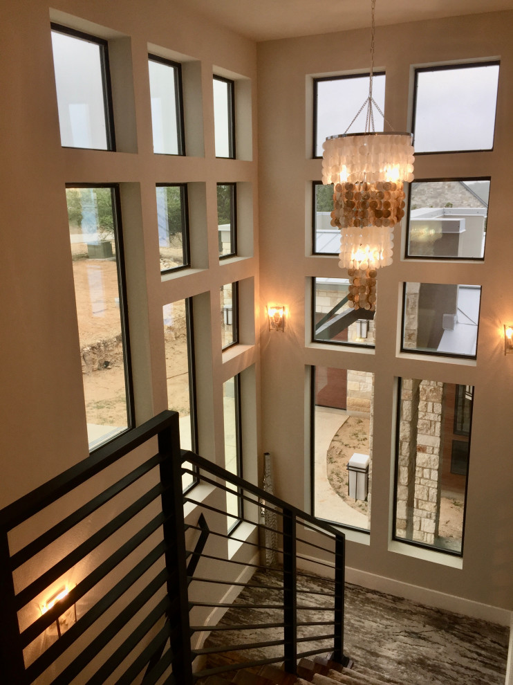 Пример оригинального дизайна: огромная п-образная лестница в стиле неоклассика (современная классика) с ступенями с ковровым покрытием, ковровыми подступенками и металлическими перилами