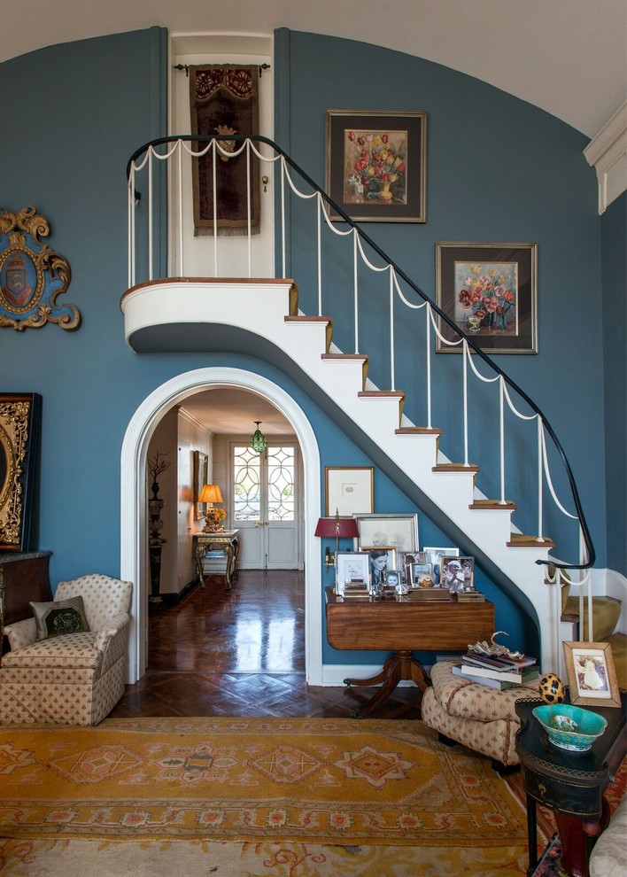 На фото: угловая лестница в классическом стиле с ступенями с ковровым покрытием, ковровыми подступенками и металлическими перилами