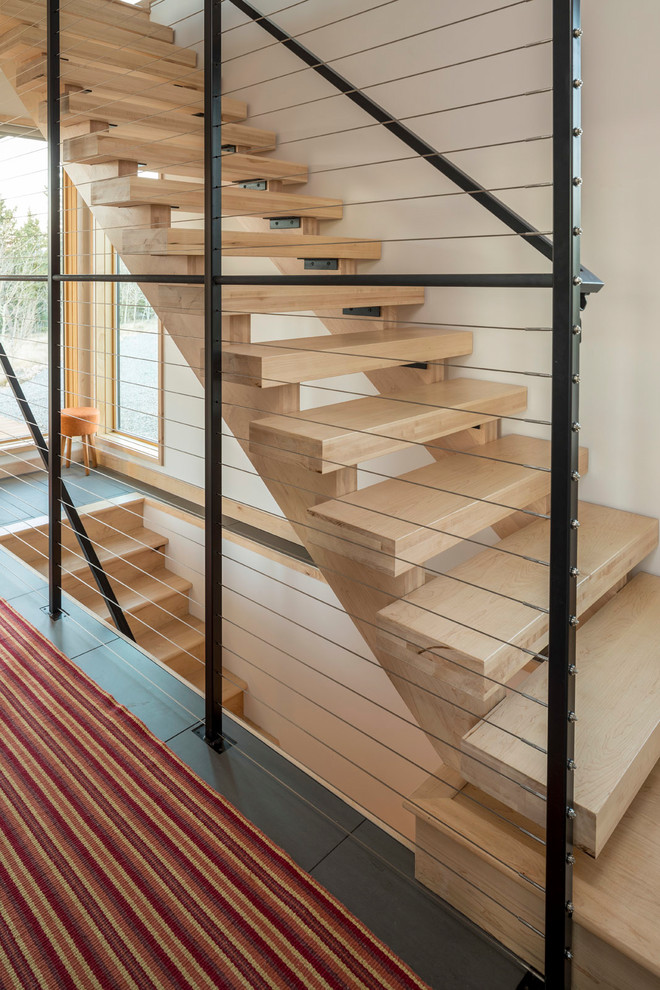 Photo of a medium sized contemporary wood straight wire cable railing staircase in Minneapolis with wood risers.