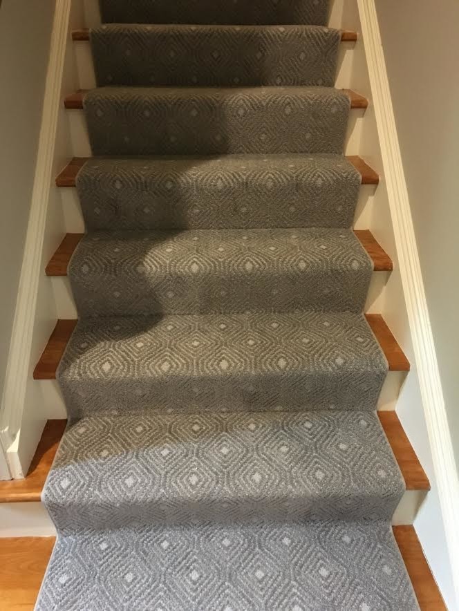 Photo of a medium sized carpeted straight staircase in New York with wood risers.