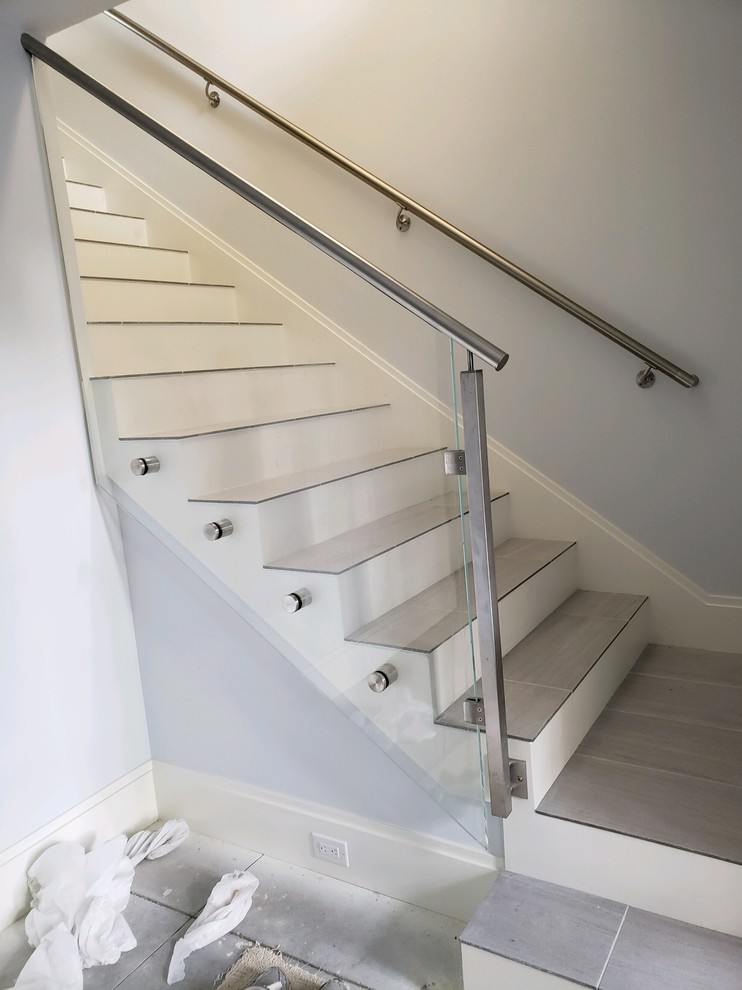 Photo of a small contemporary tiled mixed railing staircase in Other with wood risers.