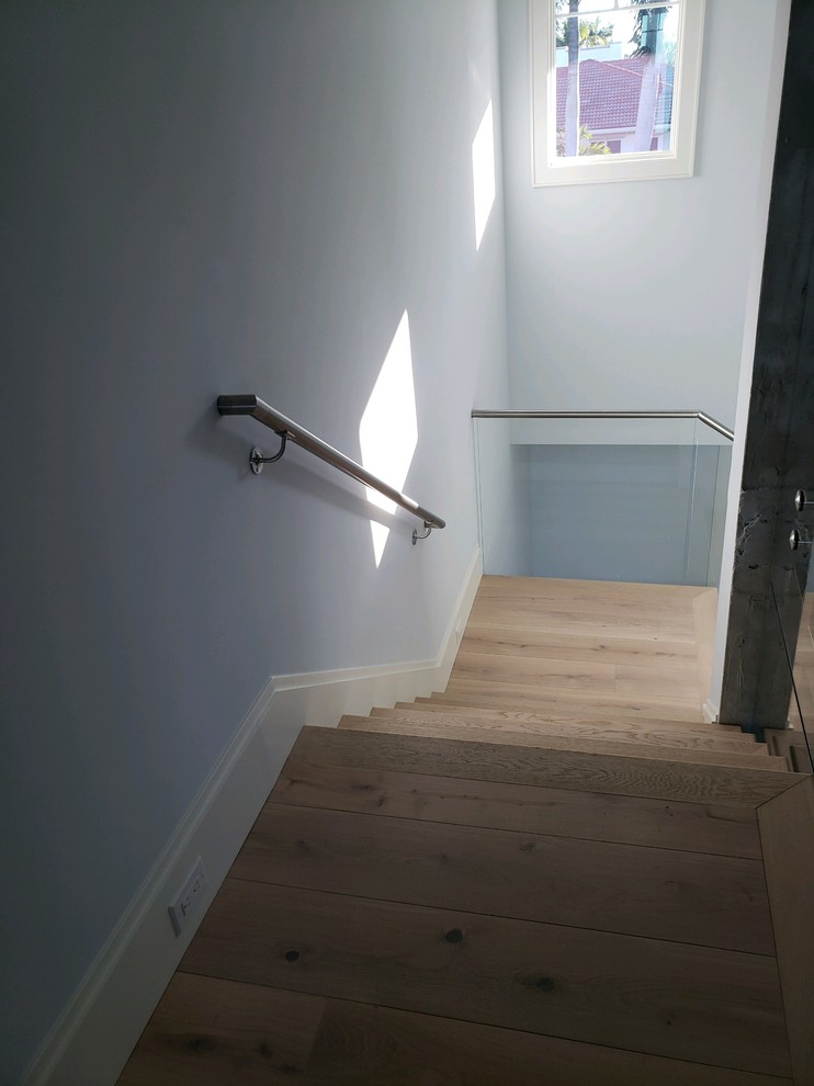 Foto de escalera contemporánea pequeña con escalones con baldosas, contrahuellas de madera y barandilla de varios materiales