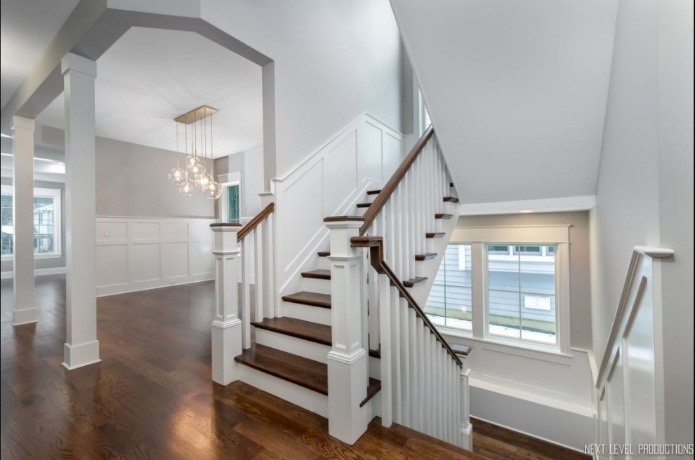 Staircase - mid-sized cottage wooden u-shaped wood railing and wainscoting staircase idea in Chicago with painted risers
