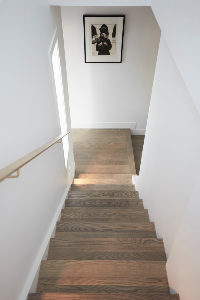 Modelo de escalera en U actual de tamaño medio con escalones de madera, contrahuellas de madera y barandilla de metal