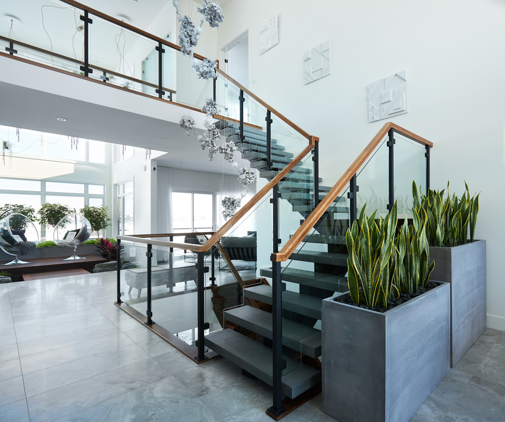 Стильный дизайн: большая лестница на больцах в стиле модернизм с бетонными ступенями и перилами из смешанных материалов - последний тренд