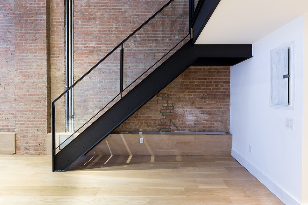 ニューヨークにあるラグジュアリーな広いインダストリアルスタイルのおしゃれな直階段 (金属の蹴込み板、金属の手すり) の写真