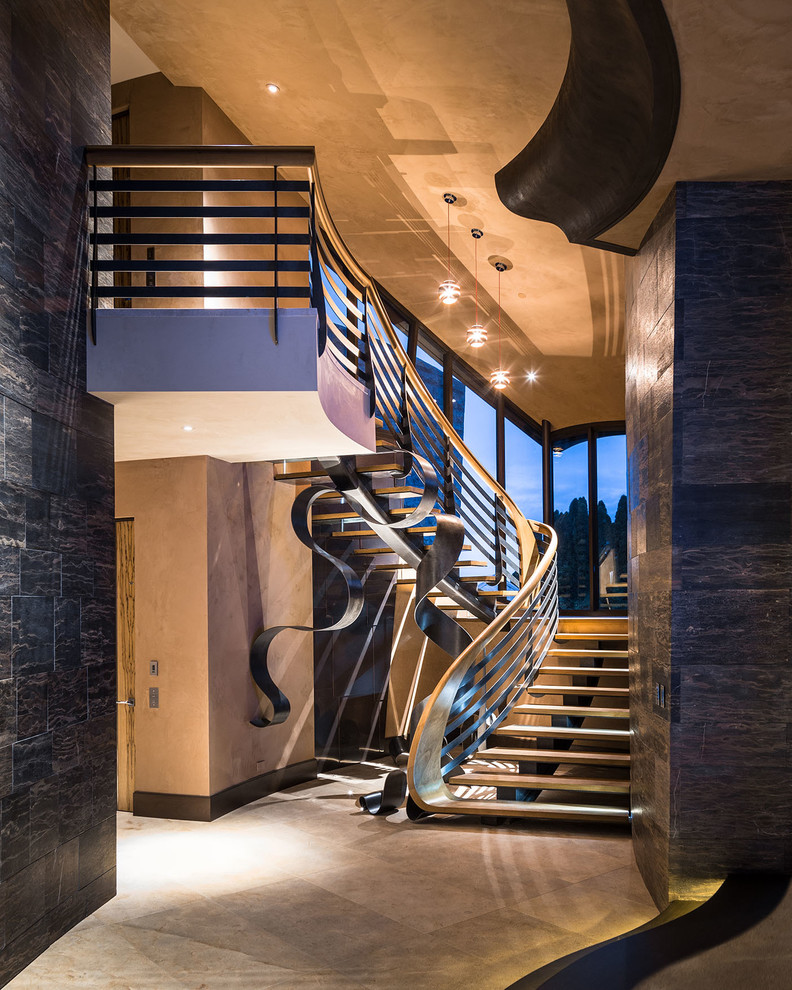 Стильный дизайн: огромная изогнутая металлическая лестница в стиле модернизм с деревянными ступенями - последний тренд