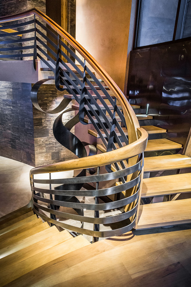 Inspiration för mycket stora moderna svängda trappor i trä, med sättsteg i metall