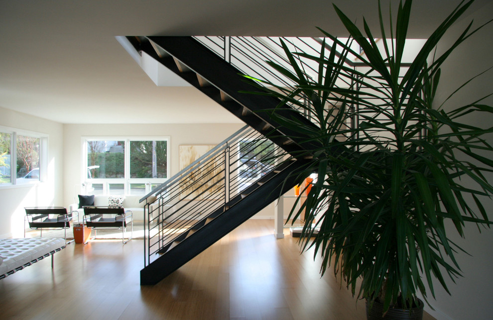 Example of a large minimalist wooden u-shaped open and metal railing staircase design in Seattle
