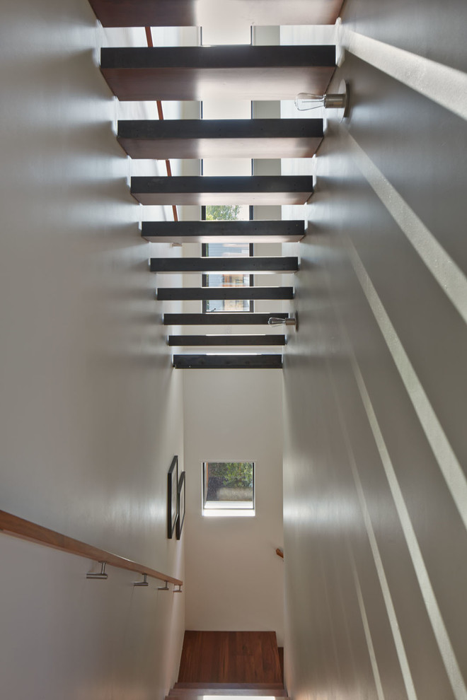 Foto de escalera recta moderna pequeña con escalones de madera y contrahuellas de metal