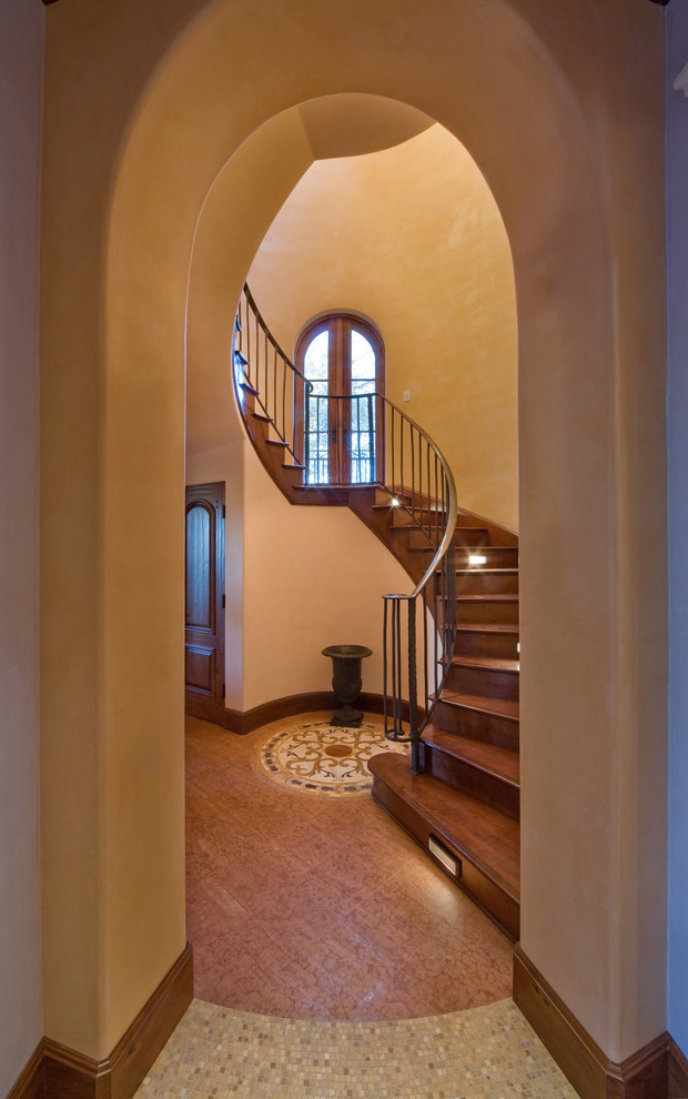 На фото: винтовая деревянная лестница среднего размера в средиземноморском стиле с деревянными ступенями