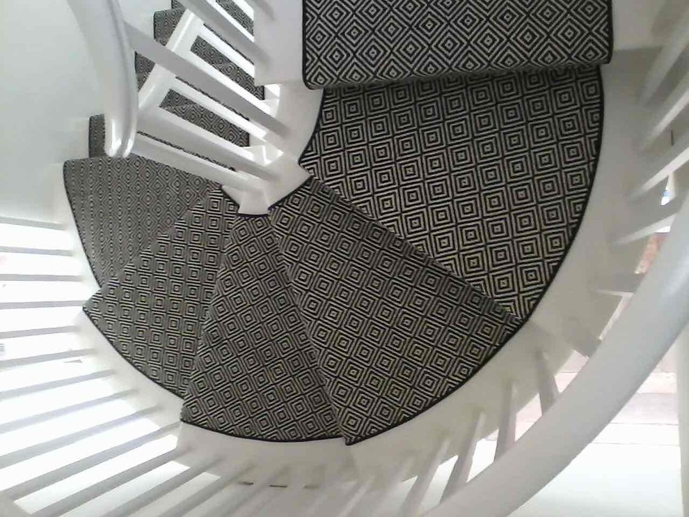 На фото: винтовая лестница в стиле неоклассика (современная классика) с ступенями с ковровым покрытием и ковровыми подступенками с