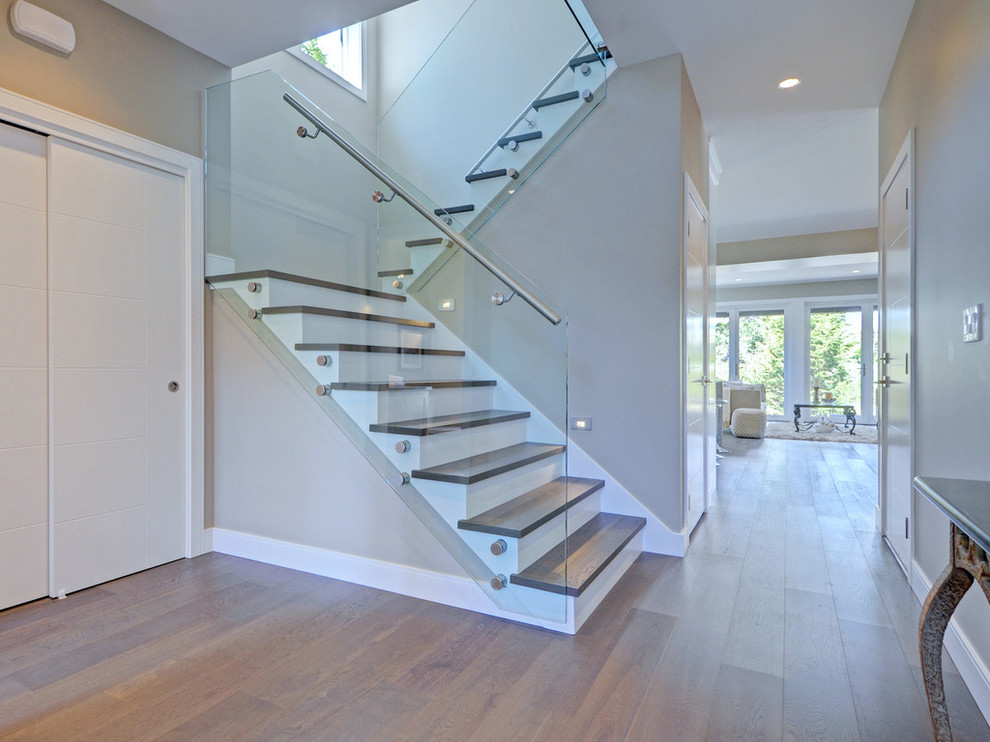 Стильный дизайн: п-образная лестница среднего размера в современном стиле с деревянными ступенями, крашенными деревянными подступенками и стеклянными перилами - последний тренд