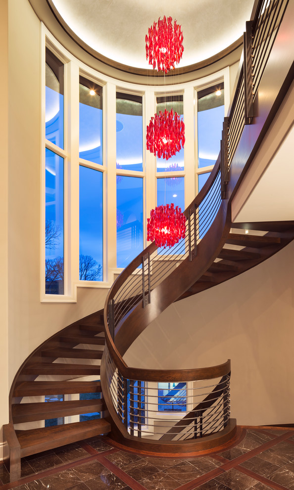 Свежая идея для дизайна: огромная винтовая деревянная лестница с деревянными ступенями - отличное фото интерьера