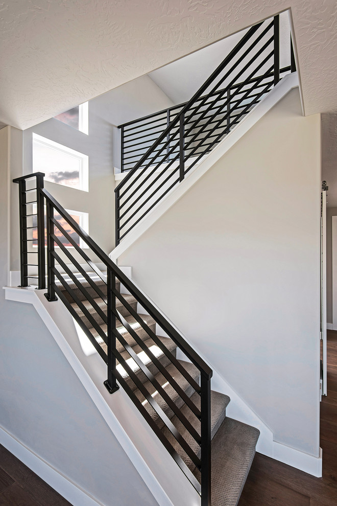 Imagen de escalera en L de estilo americano de tamaño medio con escalones enmoquetados, contrahuellas enmoquetadas y barandilla de metal
