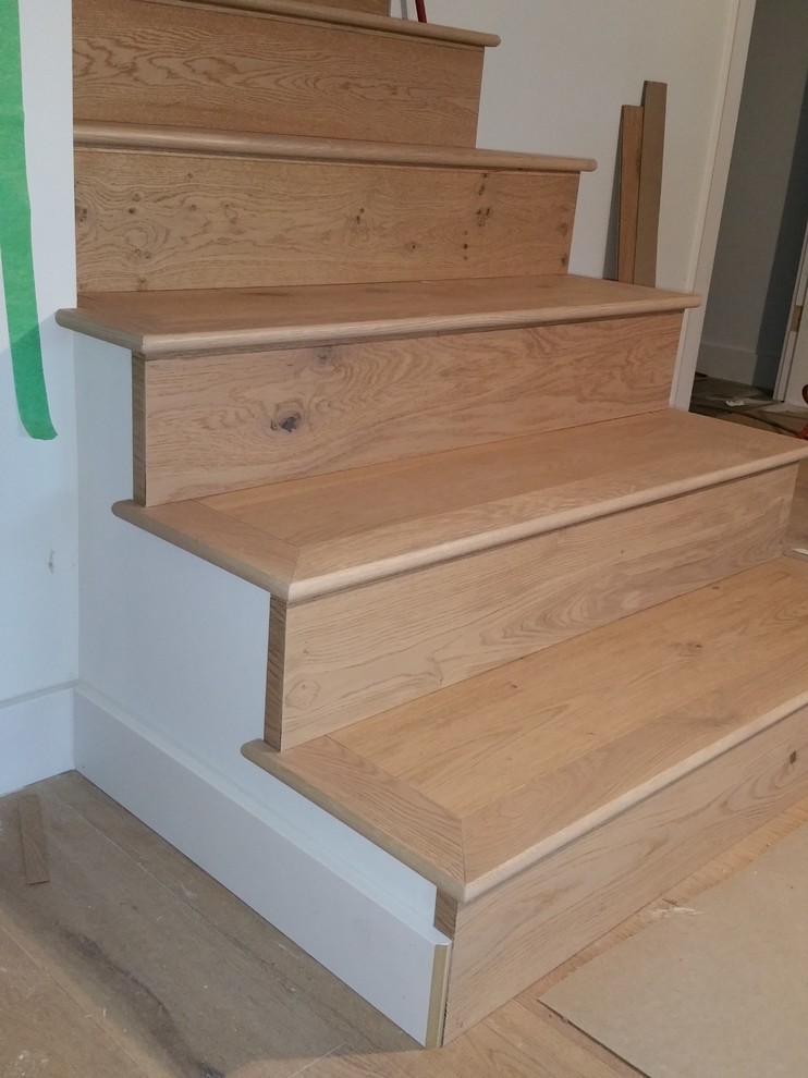 На фото: угловая деревянная лестница среднего размера в стиле модернизм с деревянными ступенями с