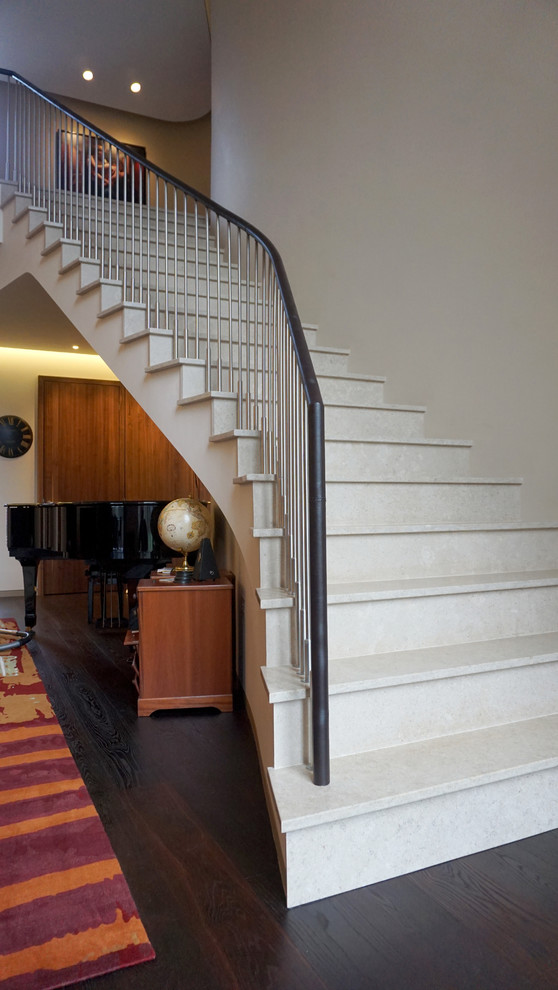 Cette photo montre un grand escalier carrelé courbe avec des contremarches carrelées.