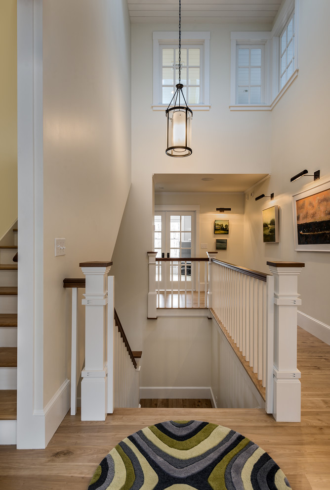 Inspiration for a large timeless wooden u-shaped staircase remodel in Portland Maine with wooden risers