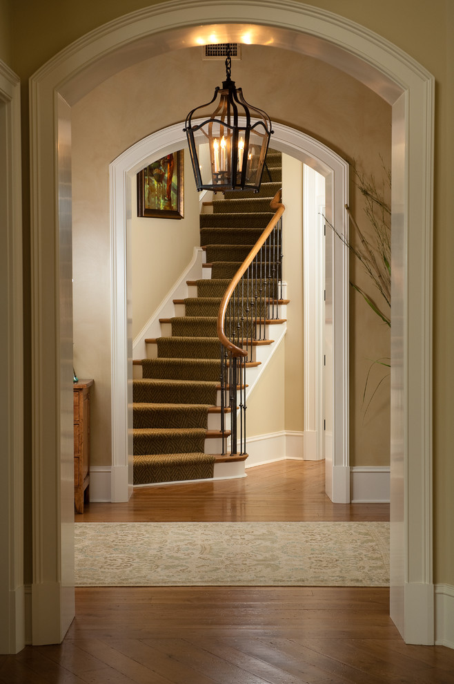 Staircase - mid-sized traditional wooden curved staircase idea in Charleston with painted risers