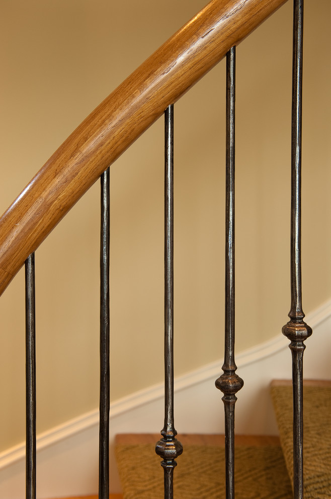Ejemplo de escalera curva clásica pequeña con escalones de madera y contrahuellas de madera pintada