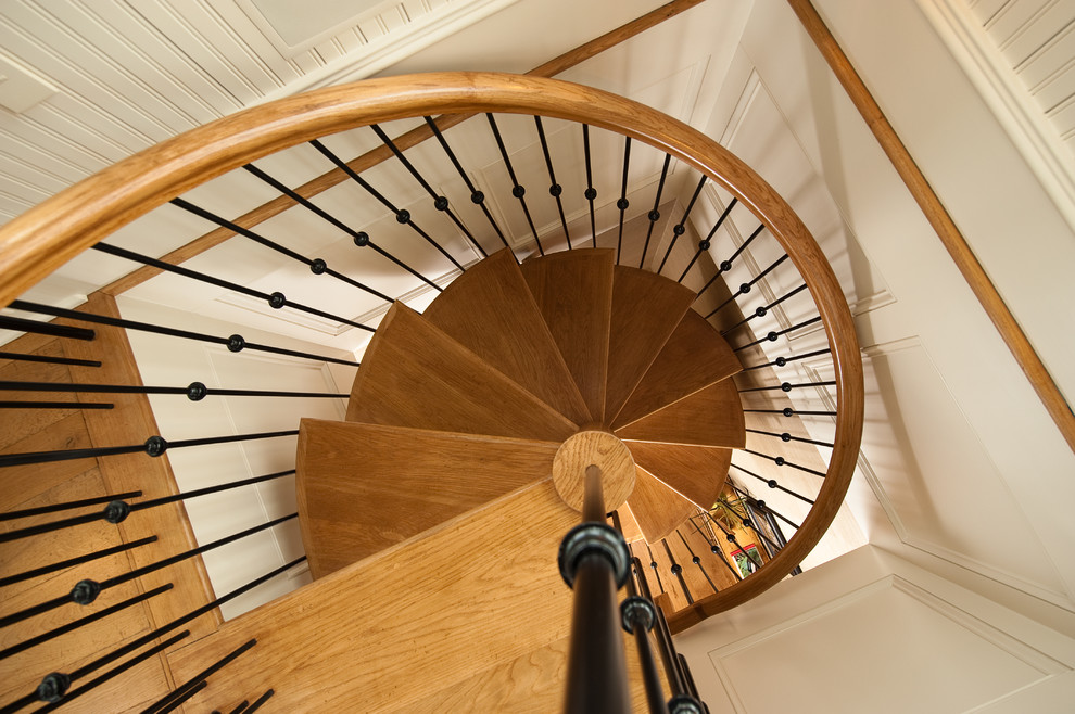 Ejemplo de escalera de caracol clásica pequeña con escalones de madera y contrahuellas de madera pintada
