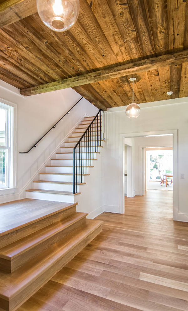 Example of a large farmhouse wooden l-shaped staircase design in New York with painted risers