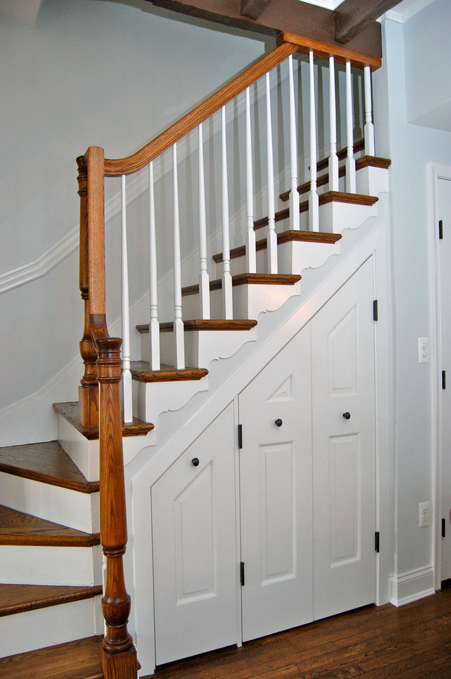 Cette photo montre un petit escalier peint courbe chic avec des marches en bois et rangements.