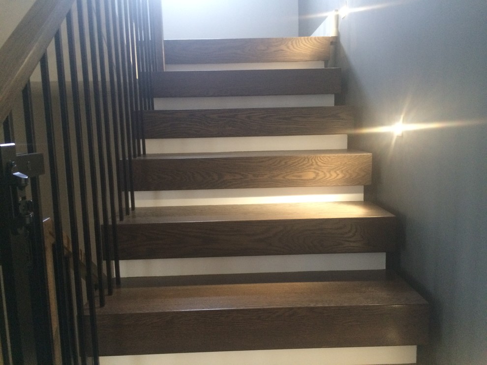 Modelo de escalera curva actual de tamaño medio con escalones de madera y contrahuellas de madera