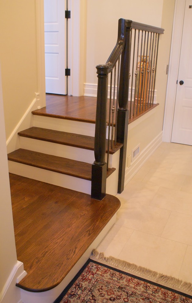 Foto de escalera en L clásica pequeña con escalones de madera, contrahuellas de madera pintada y barandilla de metal