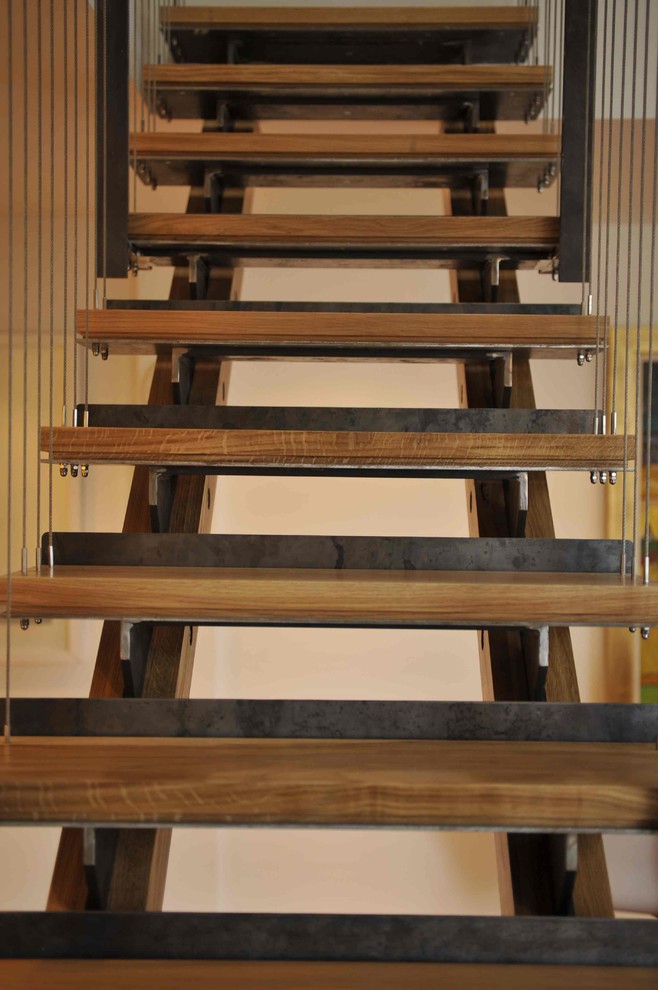 Medium sized contemporary wood straight staircase in London with open risers.