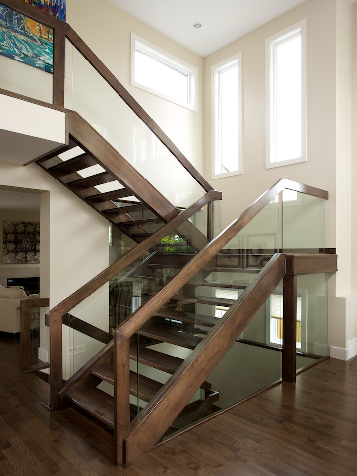 Diseño de escalera en U contemporánea sin contrahuella con escalones de madera y barandilla de varios materiales