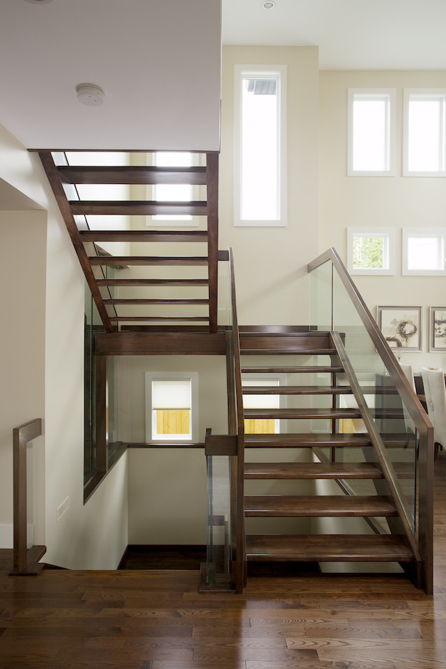 Стильный дизайн: п-образная лестница в современном стиле с деревянными ступенями и стеклянными перилами без подступенок - последний тренд