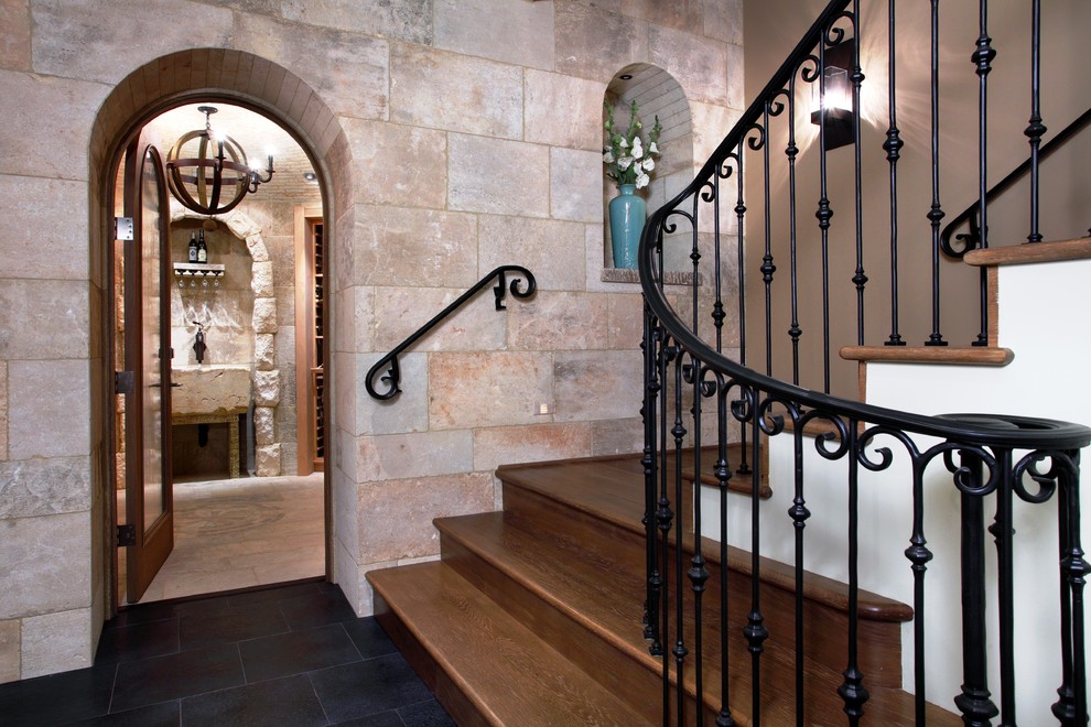 Imagen de escalera curva, mediterránea, con escalones de madera, contrahuellas de madera y barandilla de metal