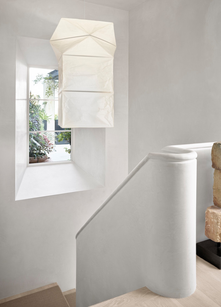 Стильный дизайн: изогнутая лестница среднего размера в стиле ретро с деревянными ступенями и ковровыми подступенками - последний тренд