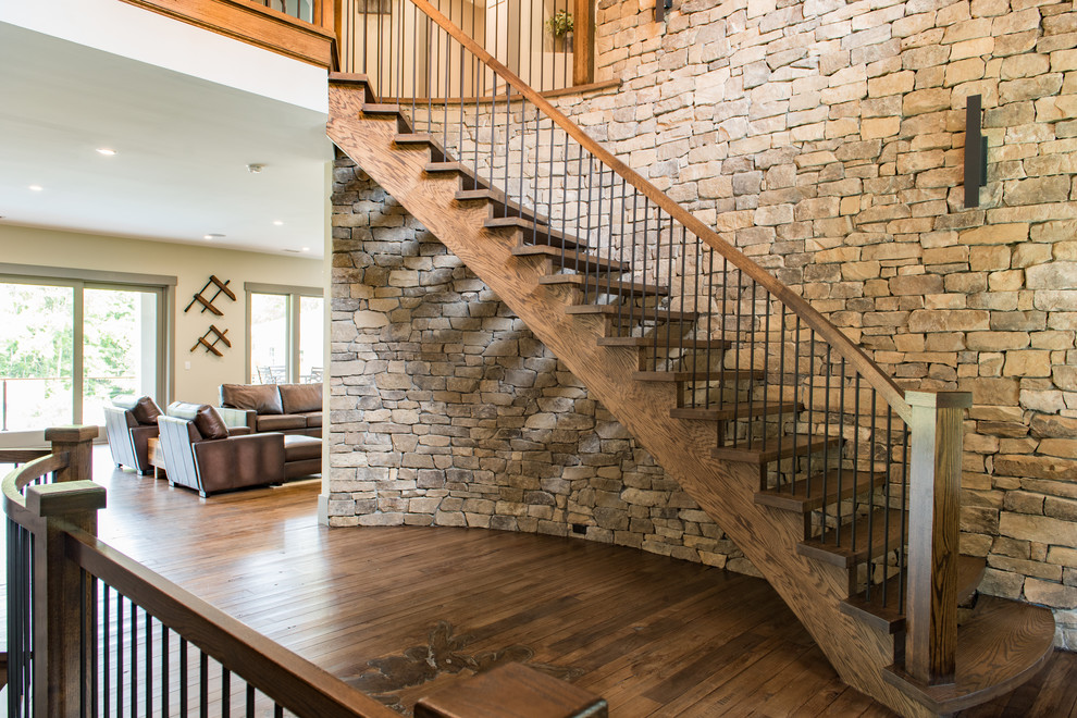 Inspiration for a large rustic wood curved mixed railing staircase in Charleston with open risers.