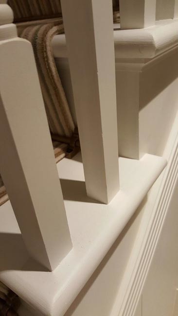 ロンドンにある中くらいなトランジショナルスタイルのおしゃれな折り返し階段 (カーペット張りの蹴込み板、木材の手すり) の写真