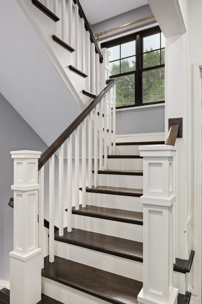 Cette photo montre un escalier chic en U de taille moyenne avec des marches en bois peint, des contremarches en bois et un garde-corps en bois.