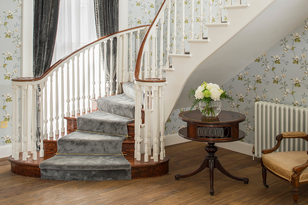 Design ideas for a large rural wood curved staircase in Dublin with wood risers.