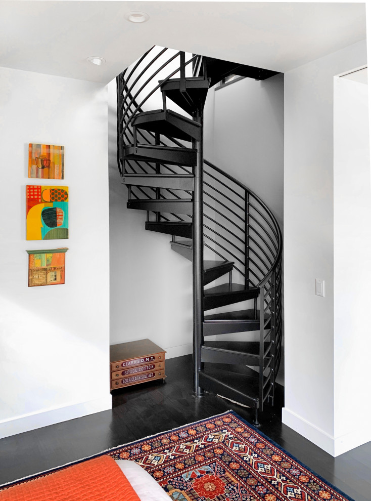 Cette image montre un escalier sans contremarche hélicoïdal vintage avec des marches en métal et un garde-corps en câble.