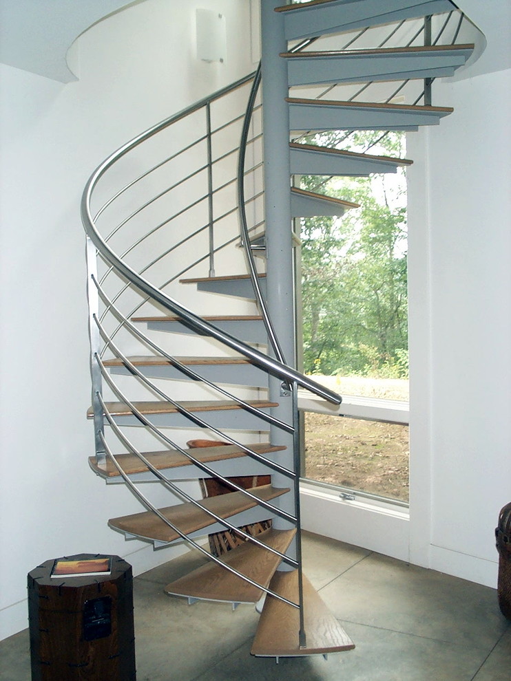 Aménagement d'un petit escalier hélicoïdal moderne avec des marches en bois, des contremarches en métal et un garde-corps en métal.