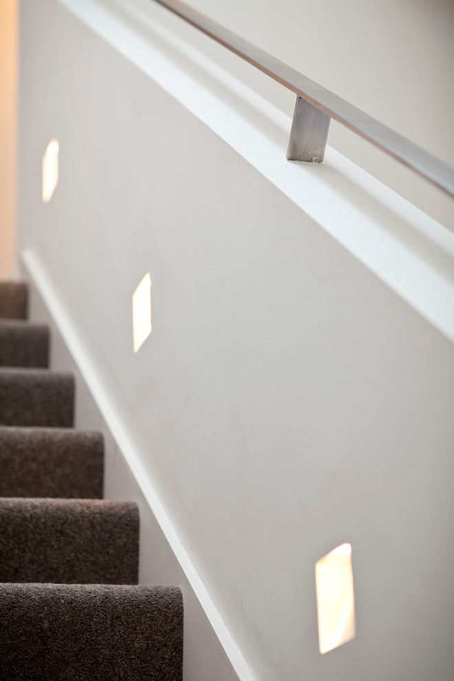 Idée de décoration pour un grand escalier design en U avec des marches en moquette et des contremarches en moquette.