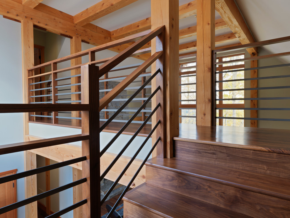 Réalisation d'un grand escalier chalet en U avec des marches en bois, des contremarches en bois et un garde-corps en matériaux mixtes.