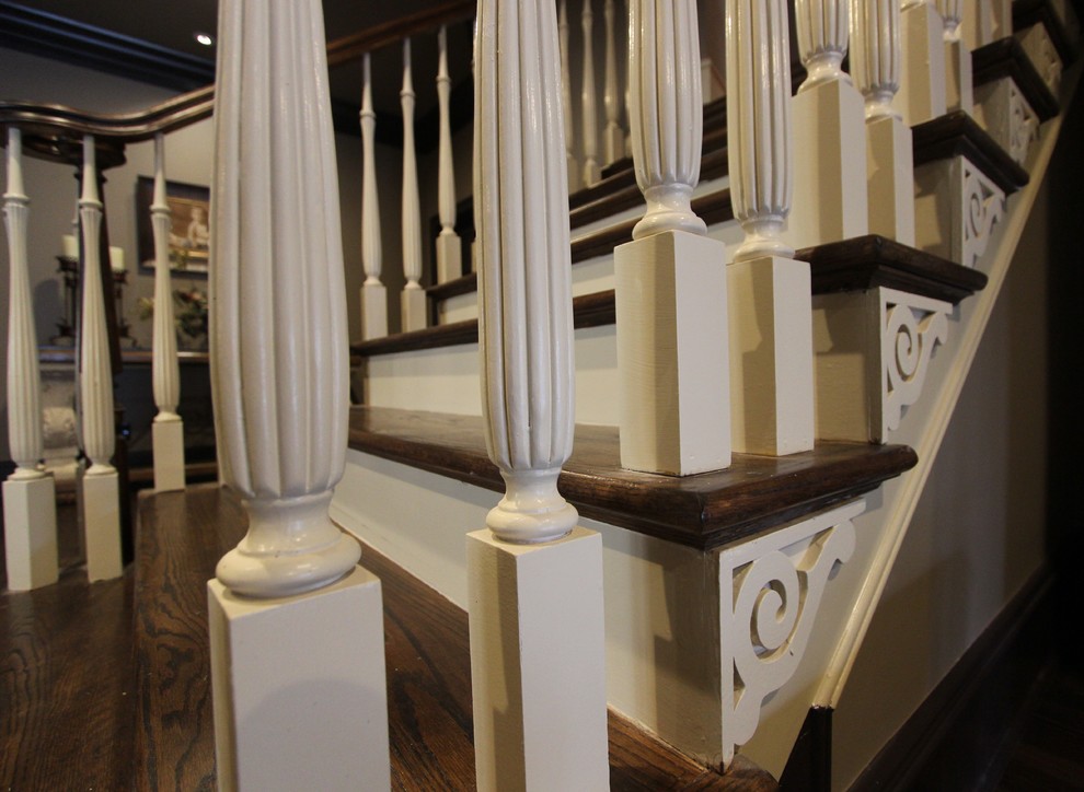 Immagine di un'ampia scala curva tradizionale con pedata in legno e alzata in legno
