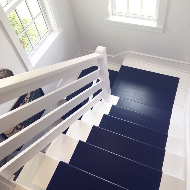 Пример оригинального дизайна: п-образная лестница в морском стиле с крашенными деревянными ступенями и крашенными деревянными подступенками