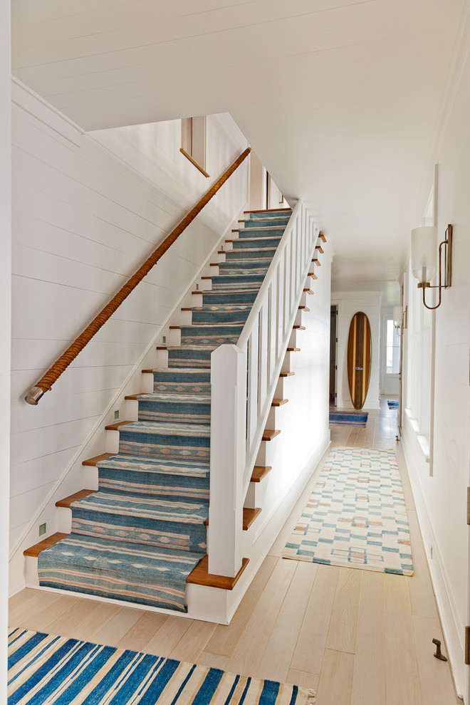 На фото: прямая лестница в морском стиле с деревянными ступенями и крашенными деревянными подступенками