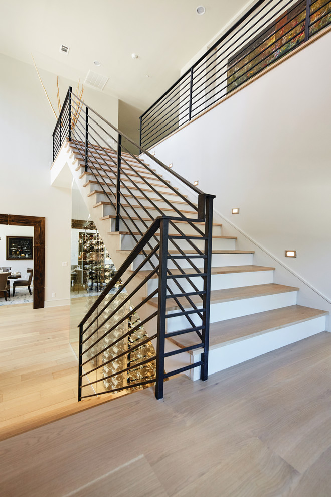 Foto de escalera en U actual grande con escalones de madera, contrahuellas de madera pintada y barandilla de metal